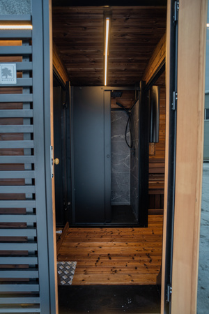 Luxuosa sauna externa moderna em formato de cubo Premium Plus para jardim com vista panorâmica durante todo o ano.